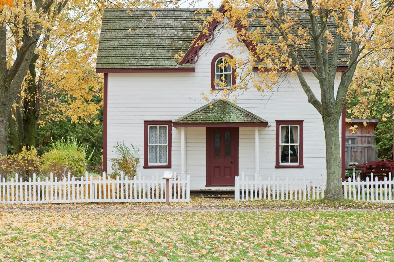 Sample: white cottage with a shingle roof in autumn